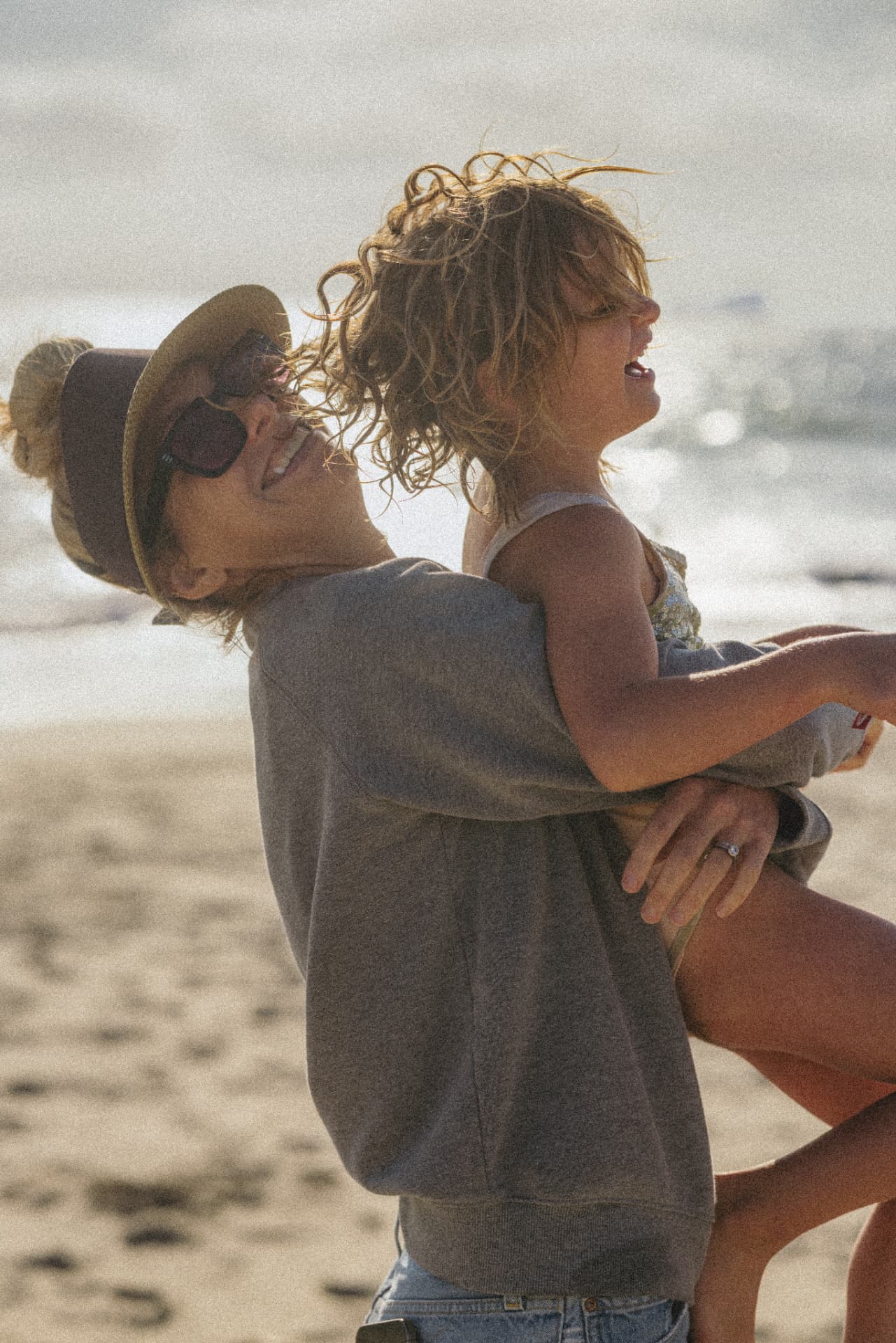 A mom and daughter laughing on the beach — photo by Kathy