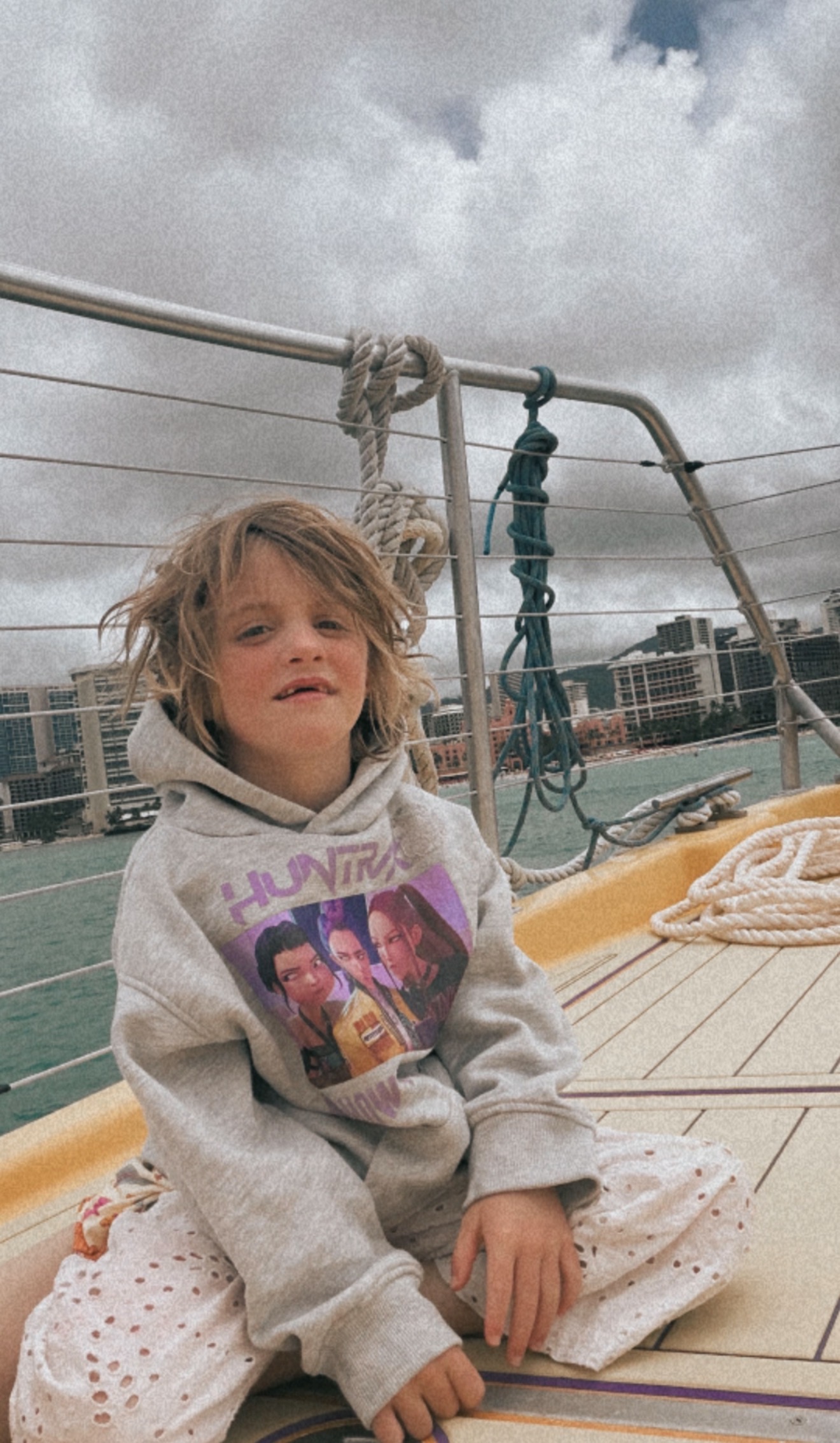 A child riding a yellow sailboat on the ocean — photo by Kathy