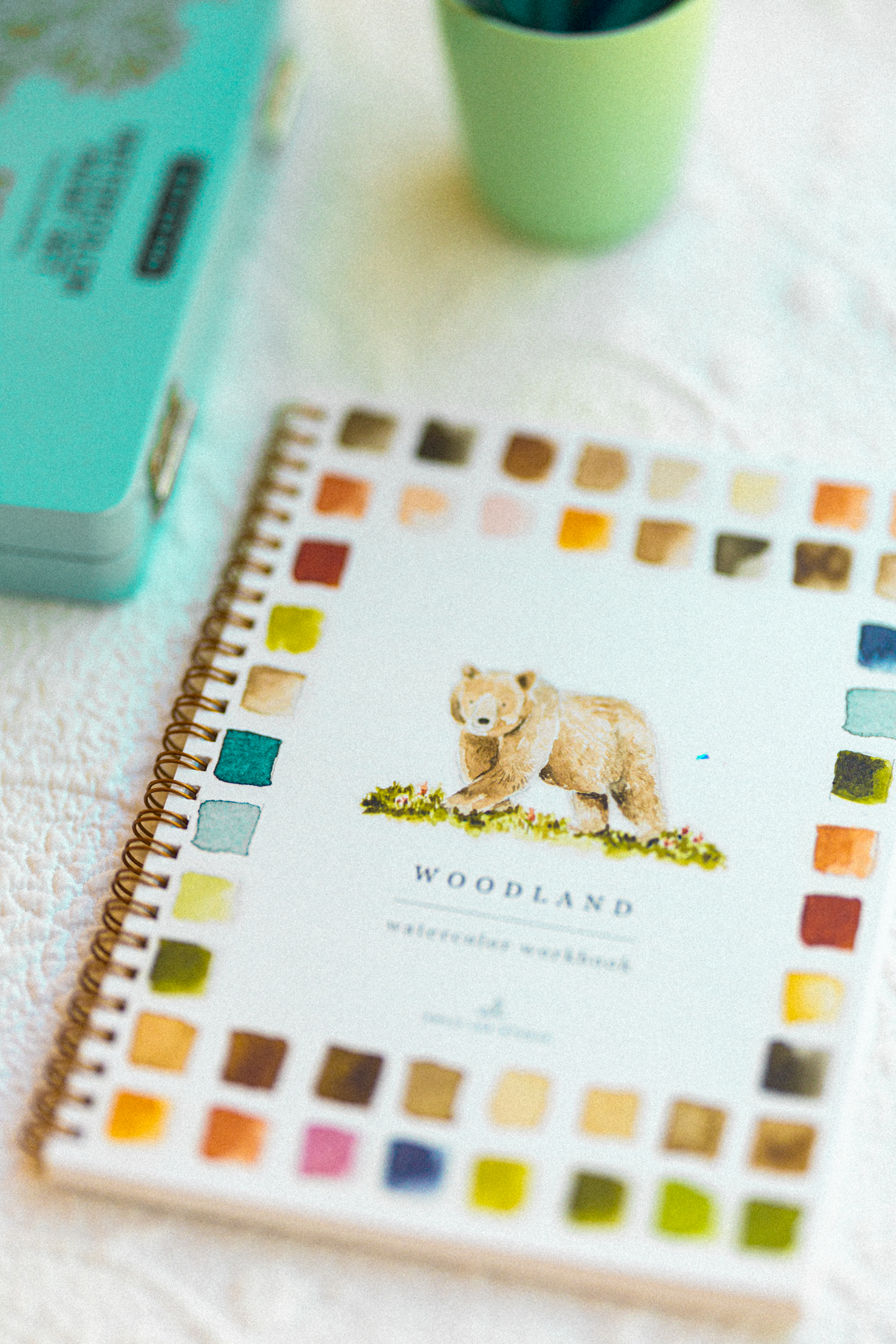 A watercolor workbook and paint tin styled on a quilt — photo by Kathy